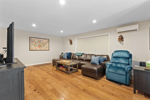 living room with baseboards, recessed lighting, a wall mounted air conditioner, and light wood-style floors