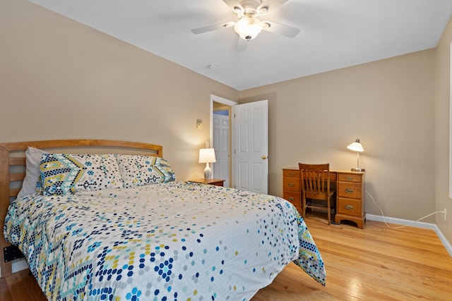 bedroom with a ceiling fan, baseboards, and wood finished floors