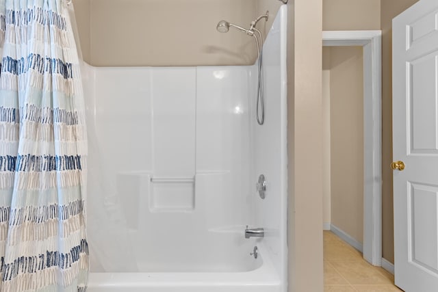 bathroom with shower / bathtub combination with curtain, baseboards, and tile patterned floors