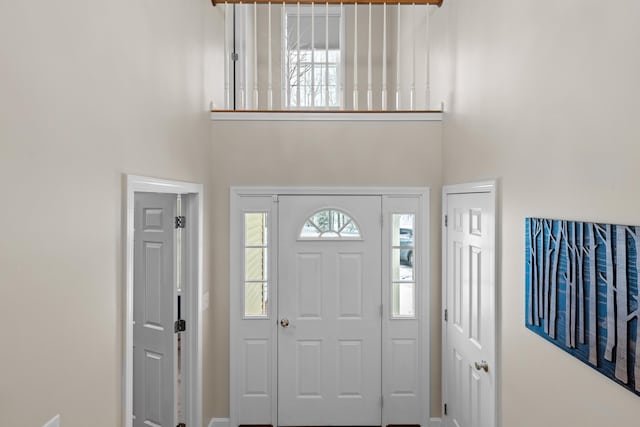 foyer entrance featuring a towering ceiling