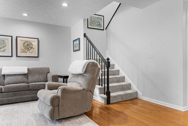 living room with baseboards, stairway, a textured ceiling, light wood-style floors, and recessed lighting