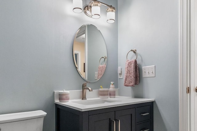 half bath featuring vanity and toilet