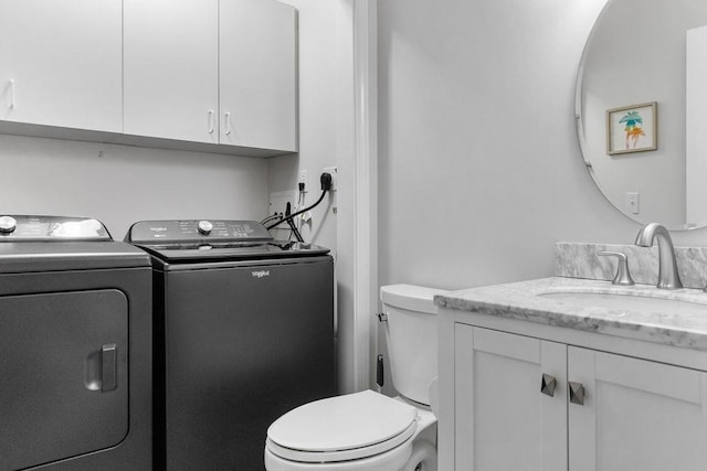 clothes washing area with laundry area, washing machine and dryer, and a sink