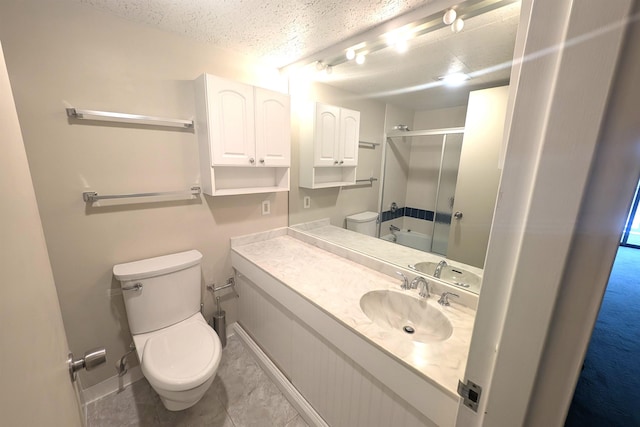 full bath featuring tile patterned flooring, baseboards, toilet, vanity, and a textured ceiling