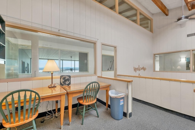 office featuring beam ceiling, a high ceiling, and built in desk