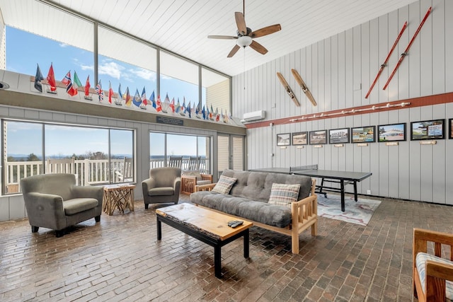 living area with brick floor, ceiling fan, and a wall mounted AC