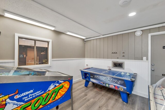 playroom featuring wood finished floors and wainscoting