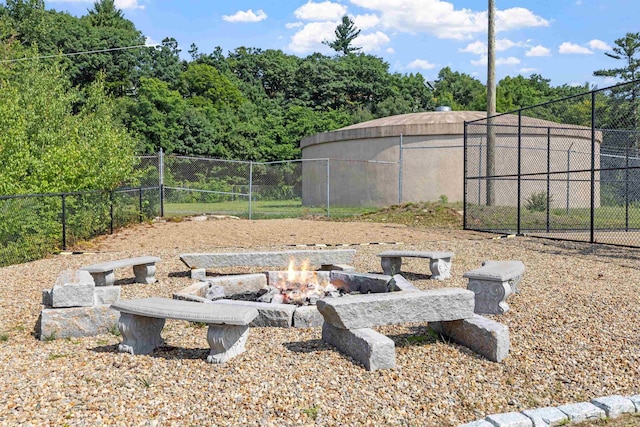 view of yard with fence and an outdoor fire pit