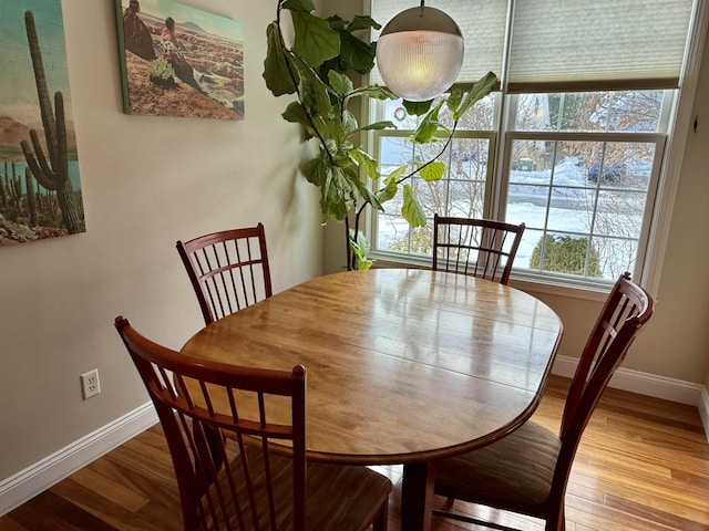 dining area with baseboards and wood finished floors