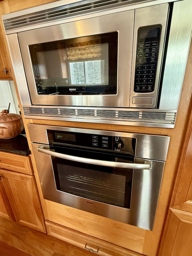 interior details featuring brown cabinetry and stainless steel microwave