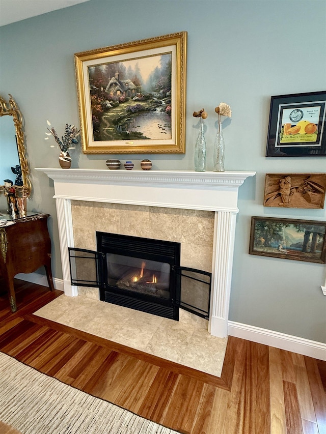 interior details with a fireplace, baseboards, and wood finished floors