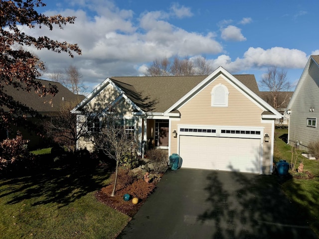 view of front of property with driveway, an attached garage, and a front yard