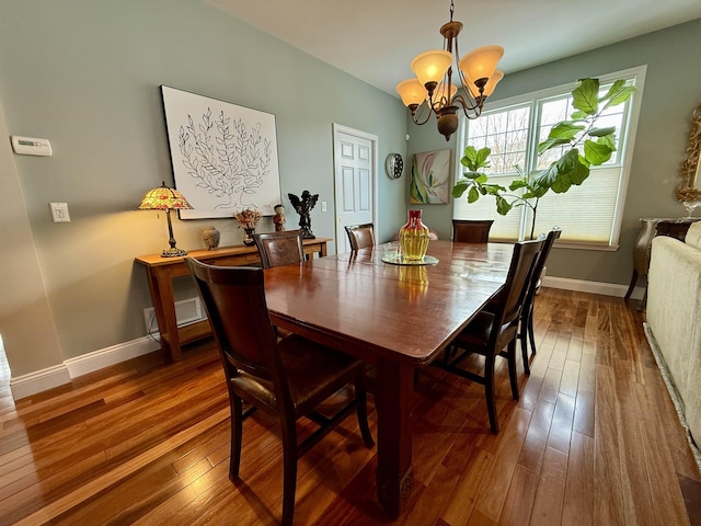 dining area featuring baseboards, a chandelier, and hardwood / wood-style floors