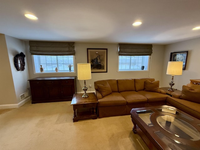 living area featuring a healthy amount of sunlight, light carpet, visible vents, and recessed lighting