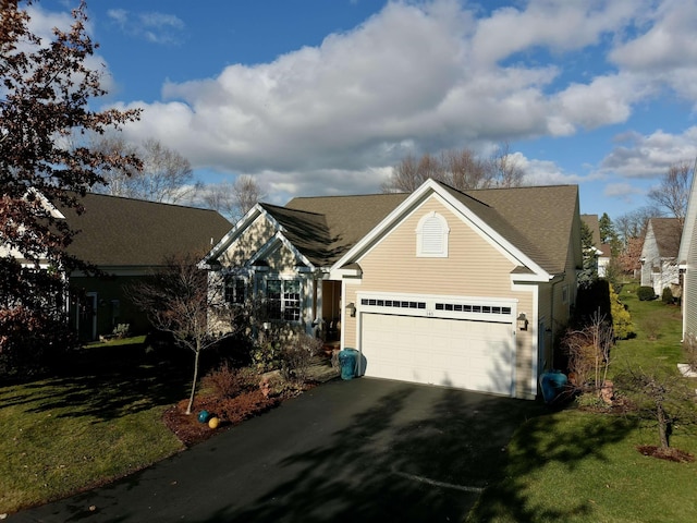 traditional-style home with aphalt driveway, a front lawn, and an attached garage