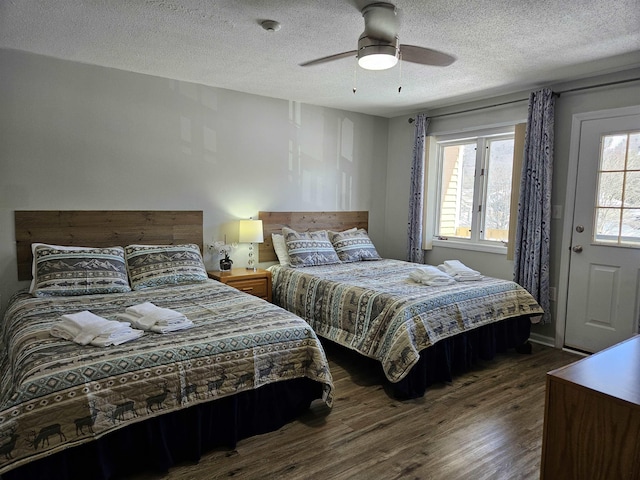 bedroom featuring dark wood-style flooring, multiple windows, and a textured ceiling