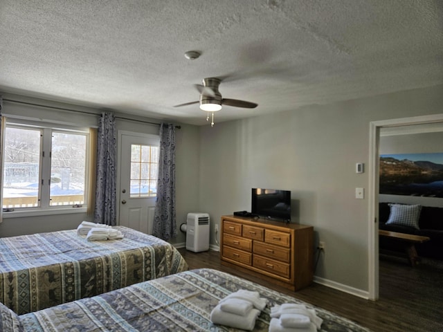 bedroom with ceiling fan, dark wood-style flooring, a textured ceiling, and baseboards