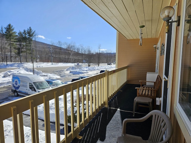 view of snow covered back of property