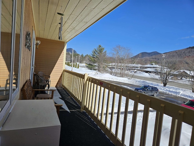 snow covered back of property featuring a mountain view