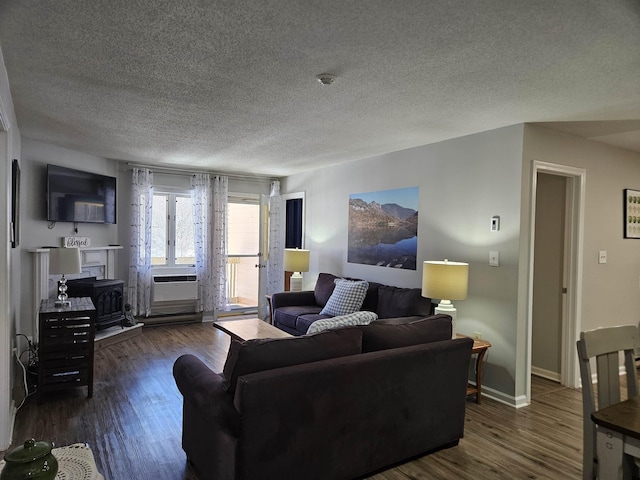 living room with a textured ceiling, cooling unit, dark wood finished floors, and baseboards