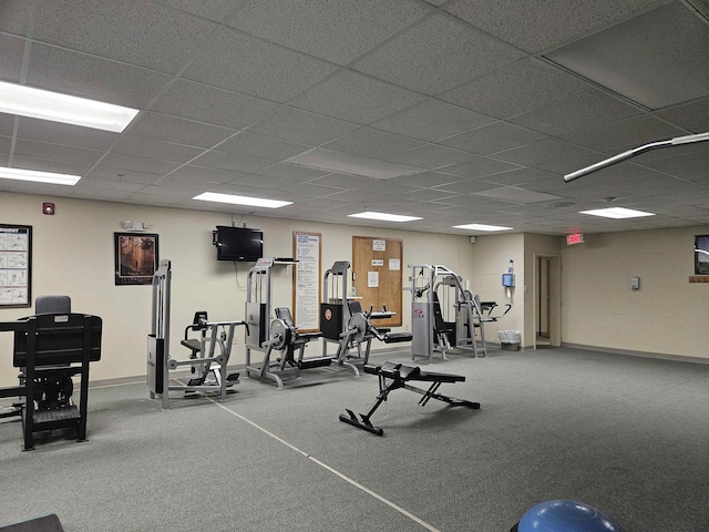 gym featuring a drop ceiling and baseboards