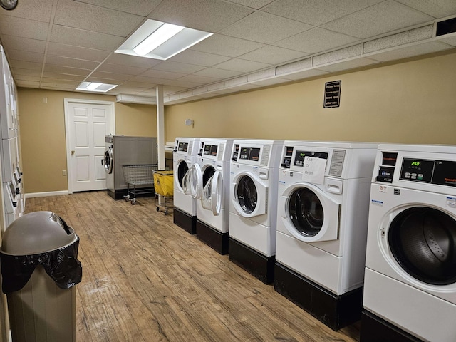 shared laundry area featuring baseboards, washer and dryer, and wood finished floors