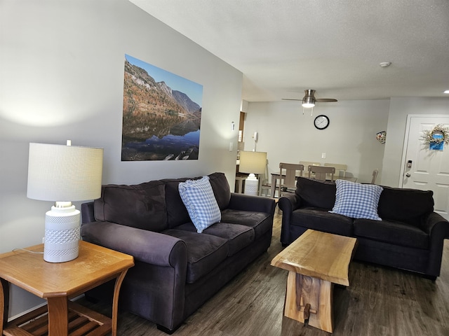 living area with a ceiling fan, a textured ceiling, and wood finished floors