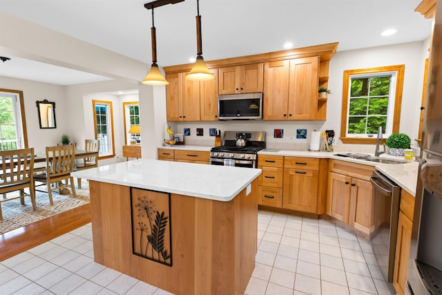 kitchen with light tile patterned floors, plenty of natural light, appliances with stainless steel finishes, and a sink