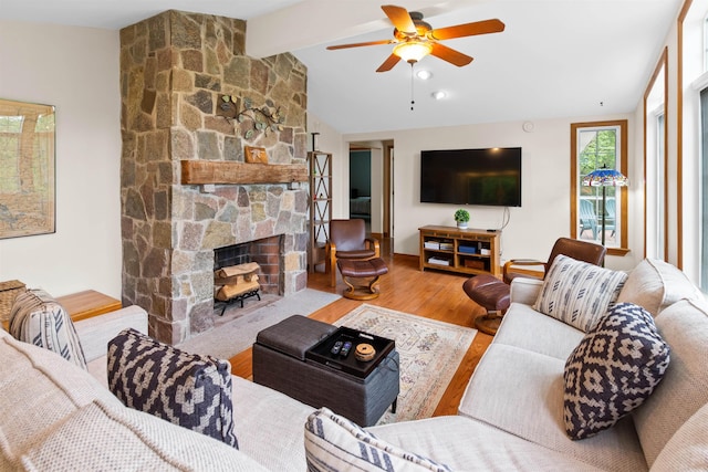 living room featuring lofted ceiling with beams, ceiling fan, a fireplace, and wood finished floors