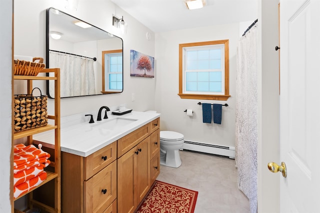 bathroom with a baseboard heating unit, plenty of natural light, vanity, and toilet