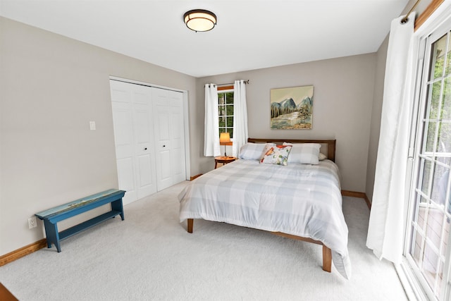 carpeted bedroom featuring a closet and baseboards