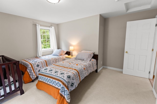 carpeted bedroom with attic access and baseboards