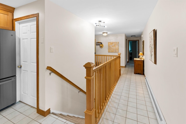 hallway featuring a baseboard radiator, light tile patterned flooring, and an upstairs landing