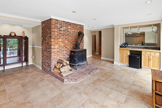 unfurnished living room featuring a wood stove, crown molding, baseboards, and light tile patterned floors