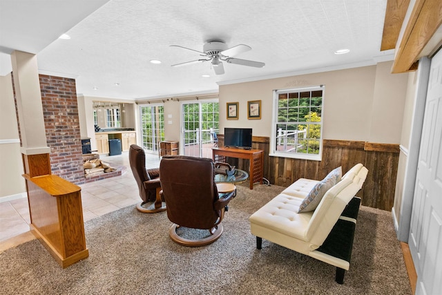 tiled living room with a wainscoted wall, ornamental molding, a textured ceiling, wood walls, and recessed lighting