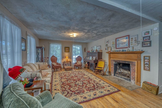 living room featuring a brick fireplace and wood finished floors