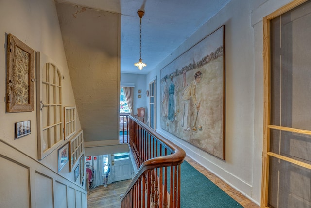 hallway featuring wood finished floors and baseboards