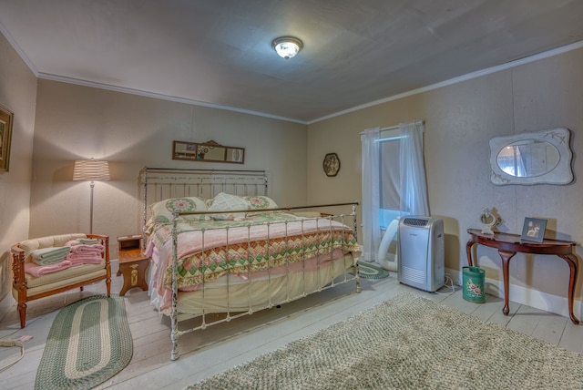 bedroom featuring crown molding and baseboards