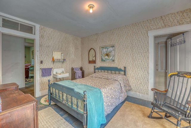 bedroom featuring wallpapered walls and wood finished floors