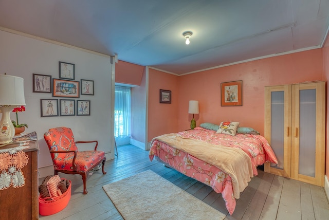 bedroom featuring wood-type flooring and crown molding