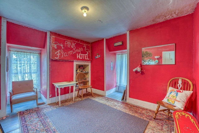 living area with wood-type flooring and baseboards