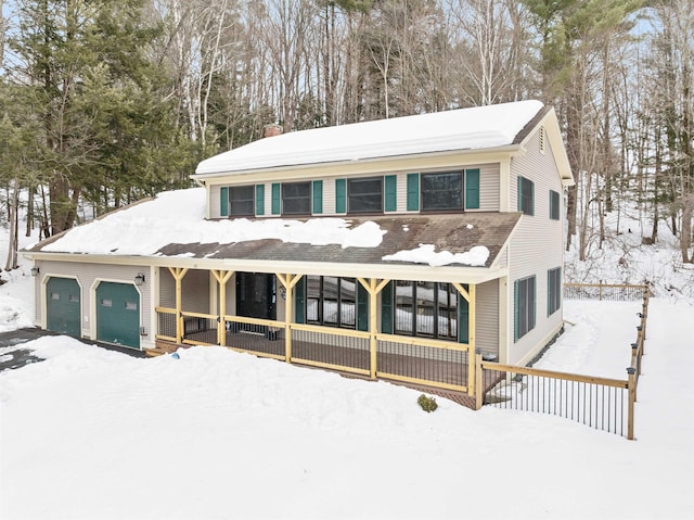 view of front of property featuring a porch, a chimney, and an attached garage