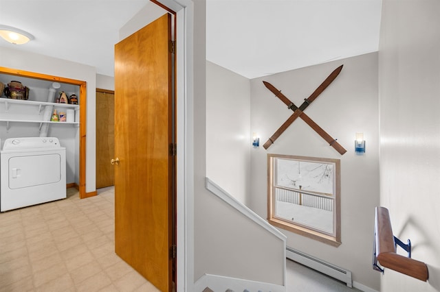 clothes washing area with washer / dryer, a baseboard radiator, and light floors