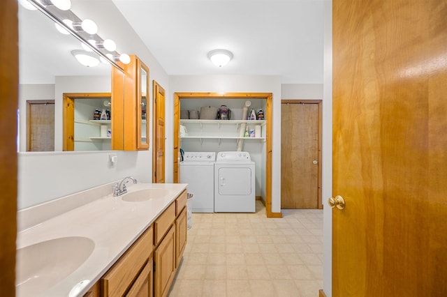 bathroom with a sink, double vanity, washer and dryer, and tile patterned floors