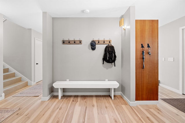 interior space featuring stairs, light wood finished floors, and baseboards