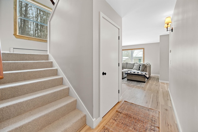 staircase featuring baseboards and wood finished floors