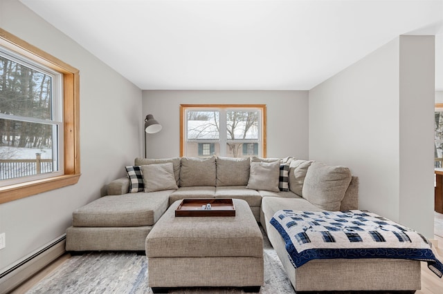 living room featuring a healthy amount of sunlight, a baseboard radiator, and wood finished floors