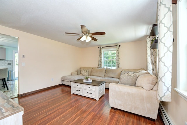 living area with ceiling fan, dark wood-style flooring, a baseboard radiator, and baseboards