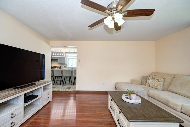 living room with ceiling fan and dark wood finished floors