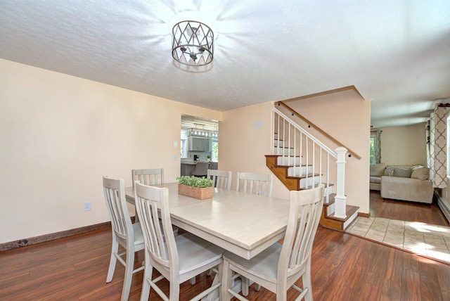 dining area with plenty of natural light, stairway, and wood finished floors